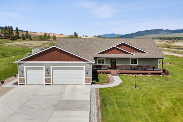 view of front facade with a mountain view, a garage, and a front lawn