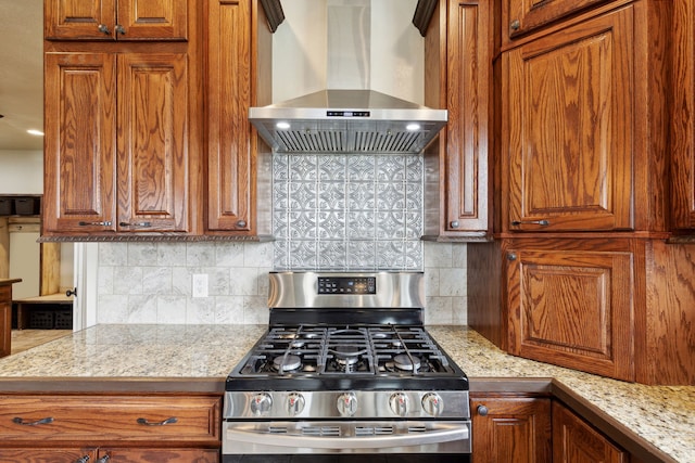 kitchen with stainless steel gas stove, tasteful backsplash, and wall chimney exhaust hood