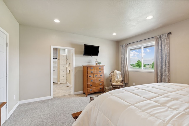 carpeted bedroom with ensuite bathroom and refrigerator