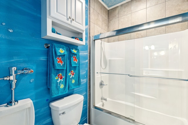 bathroom featuring toilet and combined bath / shower with glass door