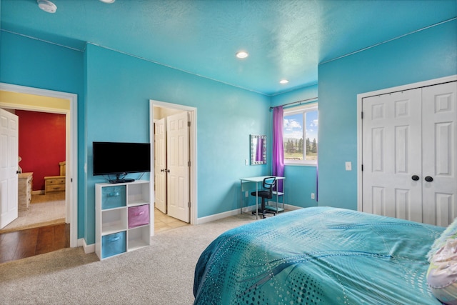 bedroom featuring a closet, light colored carpet, and a textured ceiling