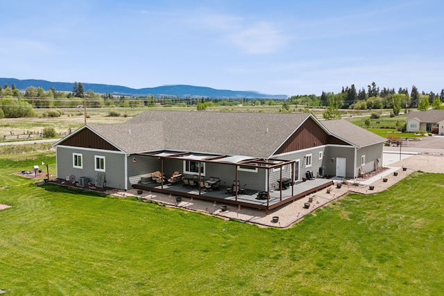 back of property featuring outdoor lounge area, a mountain view, a yard, and a patio