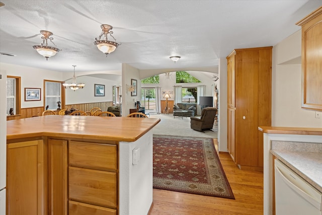 kitchen featuring light hardwood / wood-style floors, an inviting chandelier, a textured ceiling, white dishwasher, and hanging light fixtures