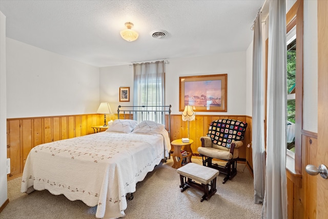 bedroom featuring a textured ceiling, carpet flooring, and multiple windows