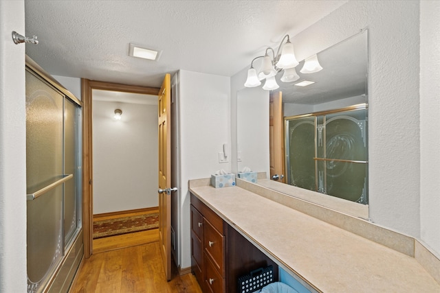 bathroom with hardwood / wood-style floors, oversized vanity, and a textured ceiling