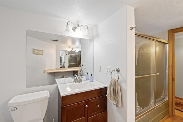 full bathroom featuring a textured ceiling, oversized vanity, toilet, and hardwood / wood-style floors