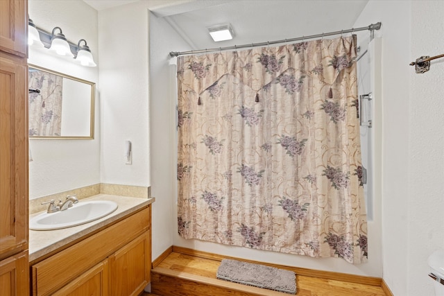 bathroom featuring wood-type flooring, vanity, and toilet