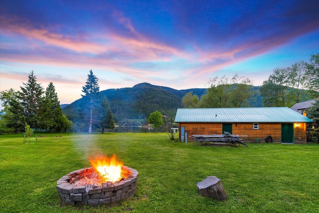 yard at dusk with a fire pit and a mountain view