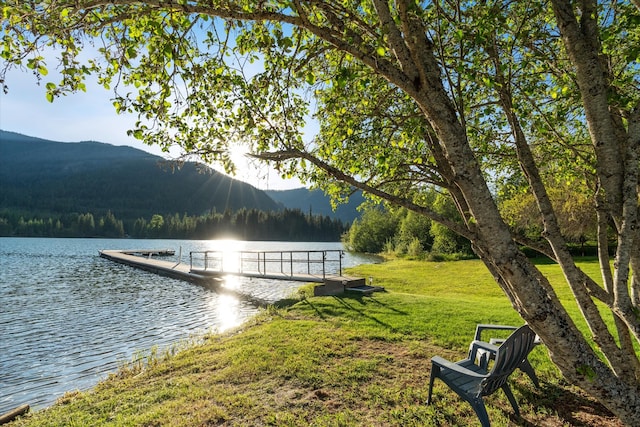 view of dock featuring a yard and a water and mountain view