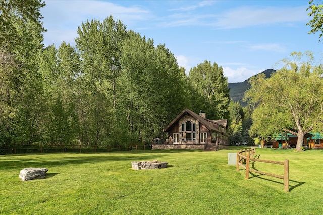 view of property's community with a fire pit and a yard