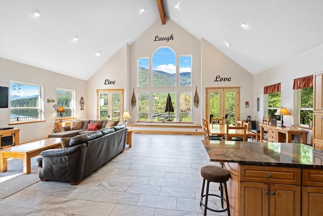 living room with beamed ceiling, french doors, and plenty of natural light