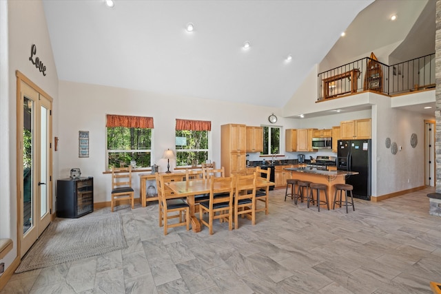 tiled dining room with high vaulted ceiling and sink