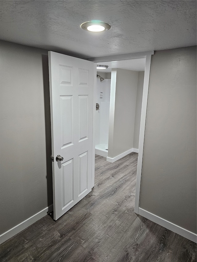 hallway with hardwood / wood-style flooring and a textured ceiling