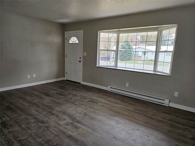 entrance foyer with dark wood-type flooring, a baseboard heating unit, and a textured ceiling