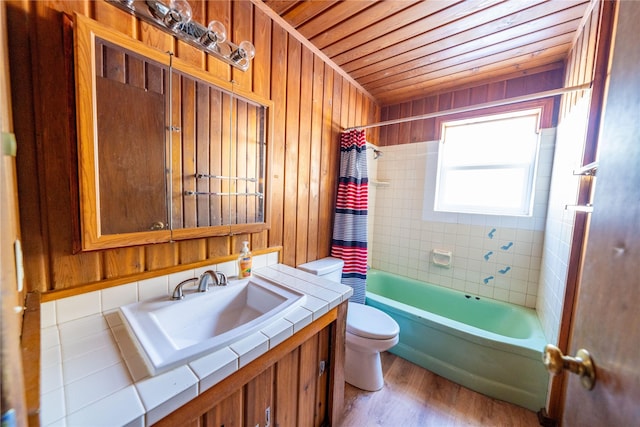 full bathroom featuring shower / bathtub combination with curtain, hardwood / wood-style floors, wood walls, and toilet