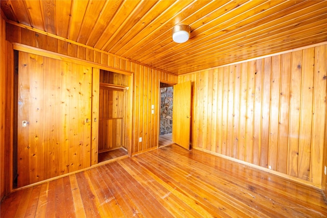 empty room featuring hardwood / wood-style flooring and wooden walls