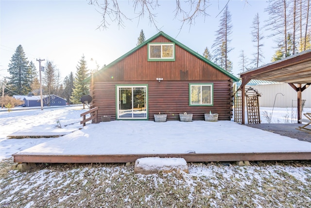 snow covered house featuring a wooden deck