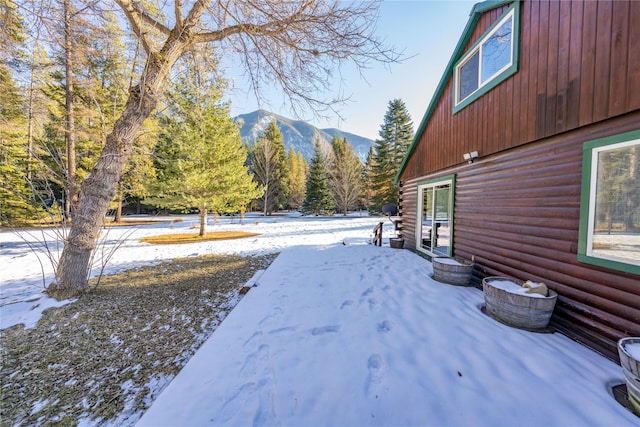 yard covered in snow featuring a mountain view