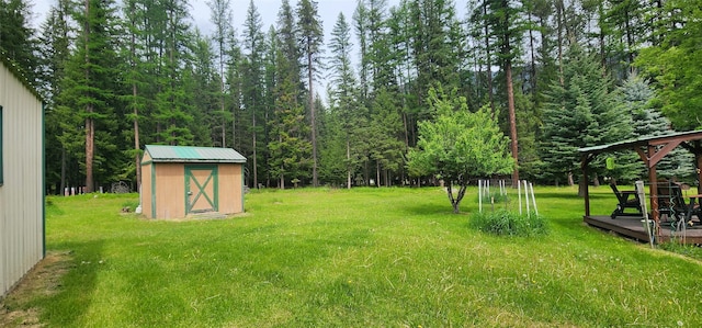 view of yard featuring a wooden deck and a storage shed