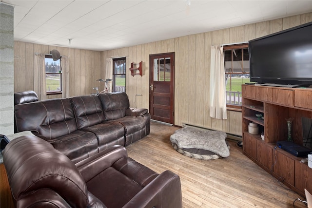 living room featuring light wood-type flooring and wood walls