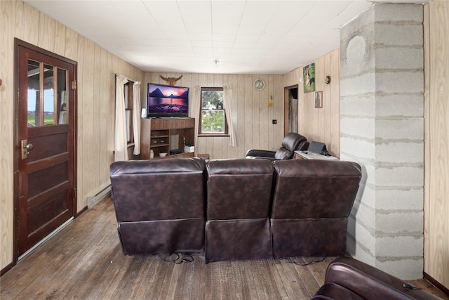 living room with wood-type flooring, a baseboard radiator, and wood walls