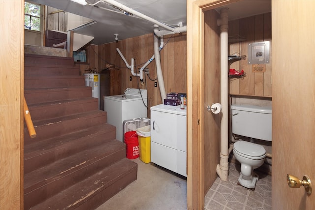 basement featuring washer and dryer, wood walls, electric water heater, and electric panel