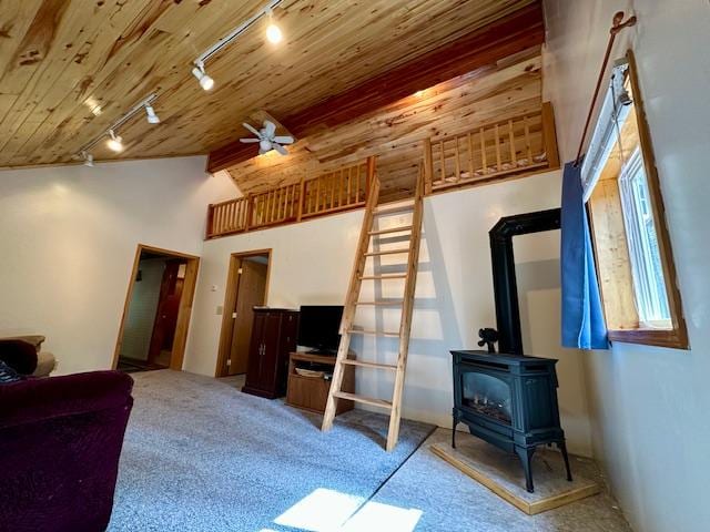 carpeted living area featuring wood ceiling, ceiling fan, vaulted ceiling, a wood stove, and track lighting