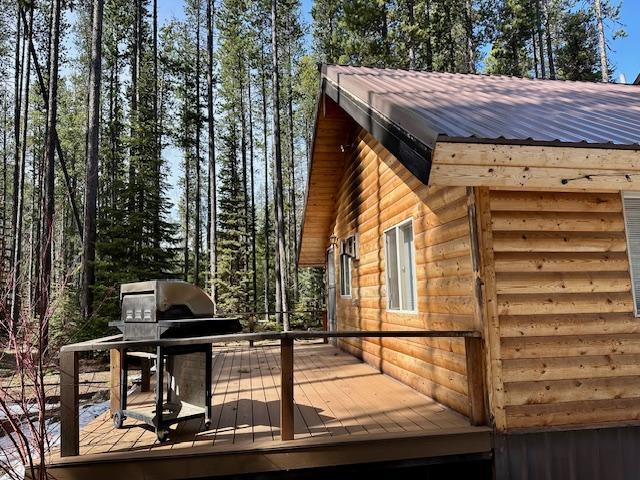 view of property exterior featuring metal roof, faux log siding, and a deck