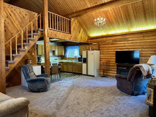 living area with light colored carpet, an inviting chandelier, high vaulted ceiling, wood ceiling, and stairway