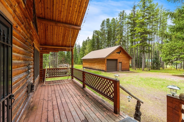 wooden terrace featuring a garage and an outbuilding