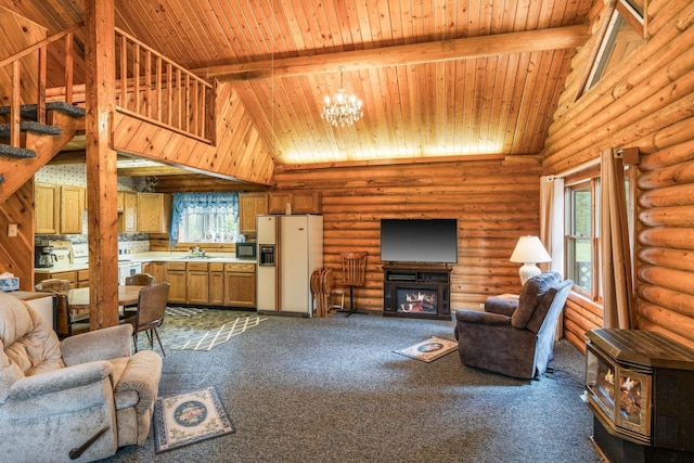 carpeted living room featuring a chandelier, high vaulted ceiling, rustic walls, and sink