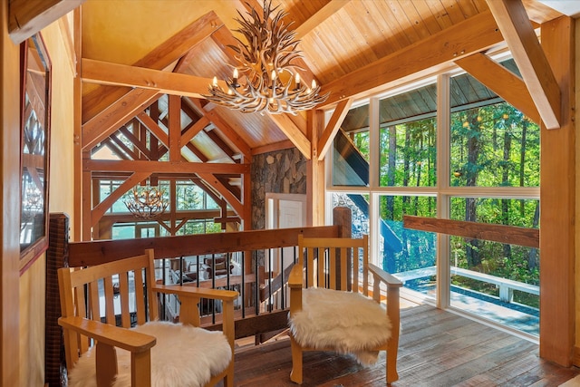 living area with vaulted ceiling with beams, wood-type flooring, a healthy amount of sunlight, a chandelier, and wood ceiling