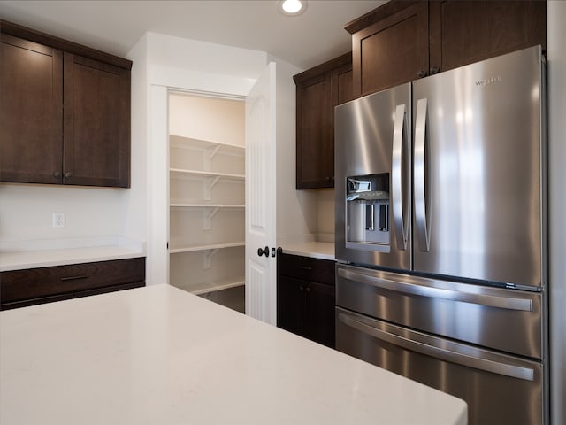 kitchen with dark brown cabinetry and stainless steel fridge with ice dispenser