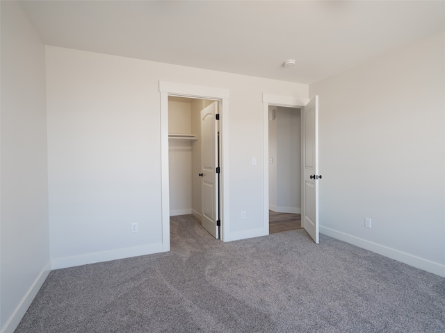 unfurnished bedroom featuring carpet floors, a closet, and a walk in closet