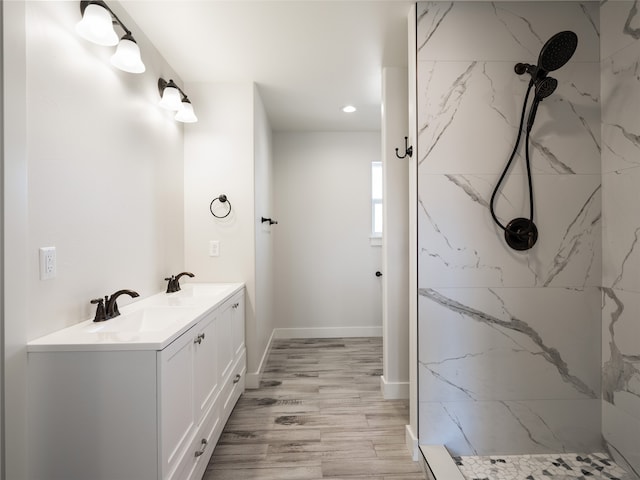 bathroom with vanity, hardwood / wood-style flooring, and tiled shower