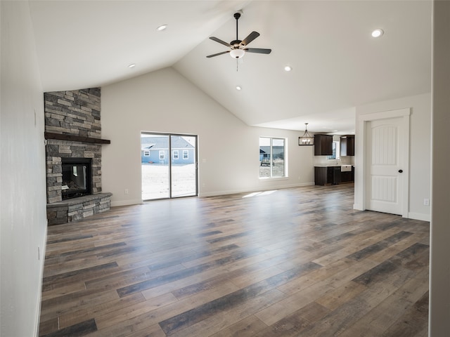 unfurnished living room featuring a fireplace, dark hardwood / wood-style flooring, ceiling fan, and high vaulted ceiling