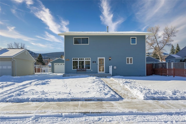 snow covered property with a garage