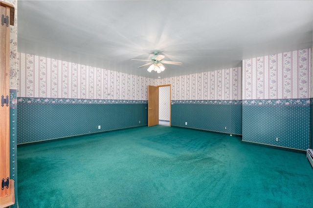 spare room with ceiling fan and dark colored carpet