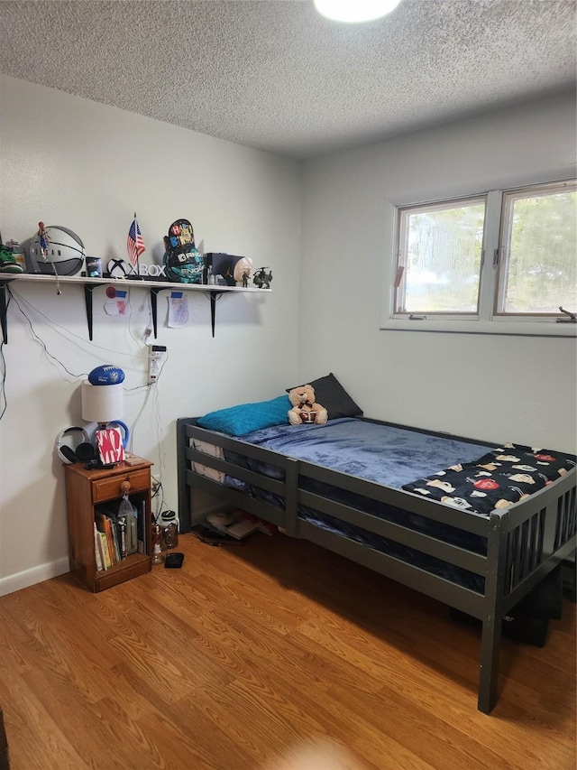 bedroom featuring a textured ceiling and light hardwood / wood-style flooring