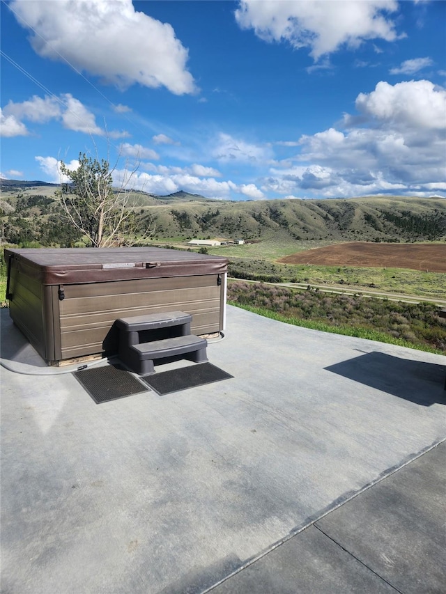 view of patio / terrace with a rural view and a hot tub