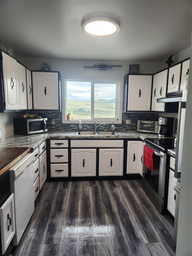 59 N Fork Rd, Townsend, MT 59644 - kitchen featuring appliances with stainless steel finishes, tasteful backsplash, white cabinetry, dark countertops, and under cabinet range hood