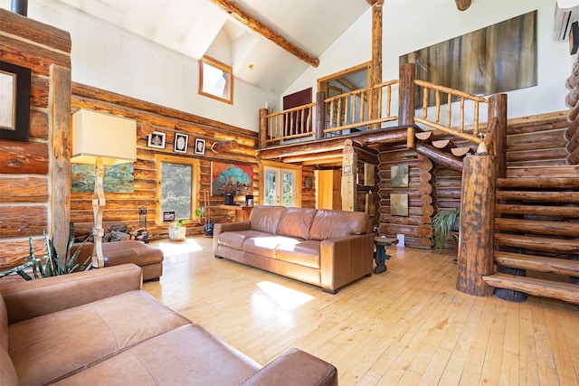 living room featuring hardwood / wood-style floors, high vaulted ceiling, and log walls