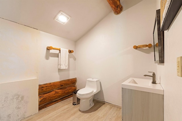 bathroom featuring toilet, vanity, hardwood / wood-style flooring, and vaulted ceiling