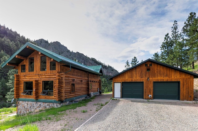 view of side of home featuring a mountain view, a garage, and an outdoor structure