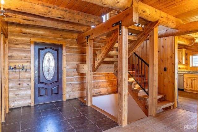 foyer entrance featuring a healthy amount of sunlight, wooden ceiling, and log walls