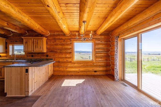 kitchen with log walls, wooden ceiling, hanging light fixtures, light hardwood / wood-style flooring, and beamed ceiling