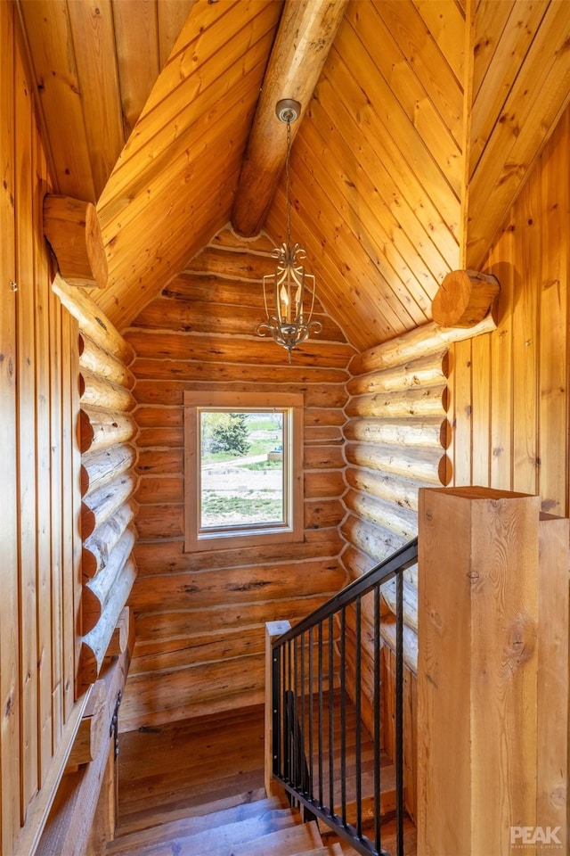 stairway with rustic walls, an inviting chandelier, wooden ceiling, and hardwood / wood-style flooring