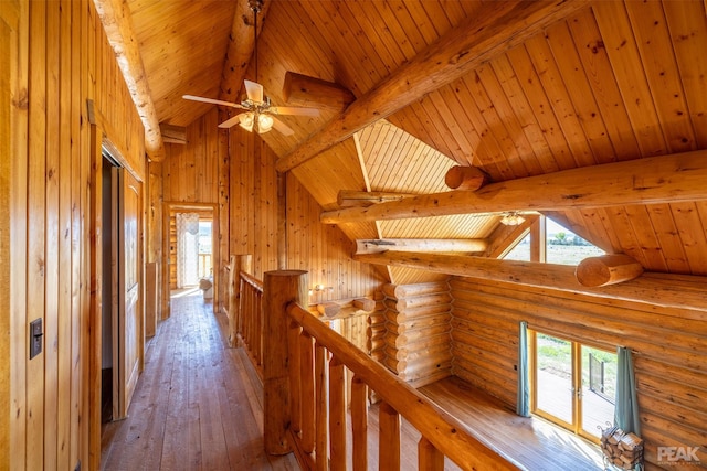 corridor with hardwood / wood-style floors, wood ceiling, a healthy amount of sunlight, and beam ceiling