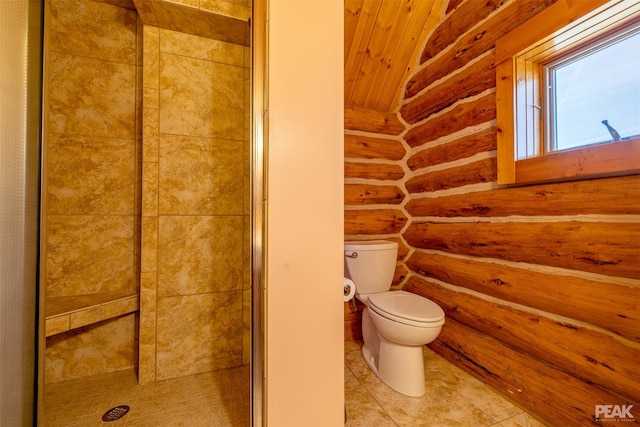 bathroom with tiled shower, tile patterned floors, and toilet