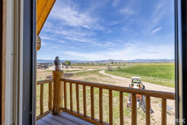 wooden terrace featuring covered porch, a mountain view, and a rural view